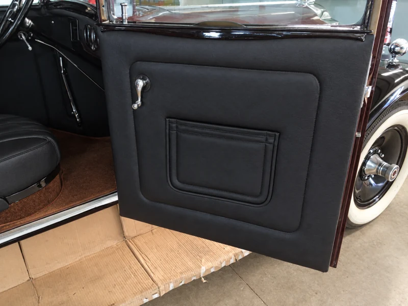 Panel negro de la puerta delantera abierta y su manilla